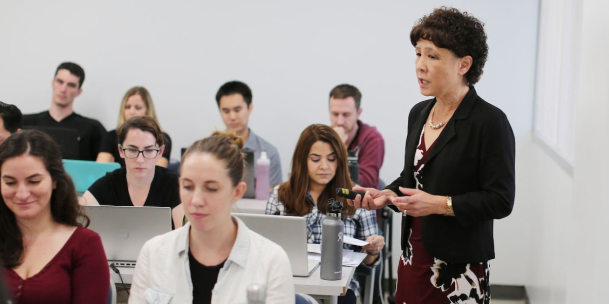 Female lecturer lecturing to her class.