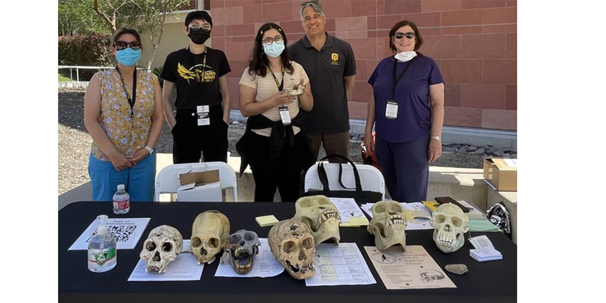 Two faculty members with three students at the Preview Day booth at Cal State LA