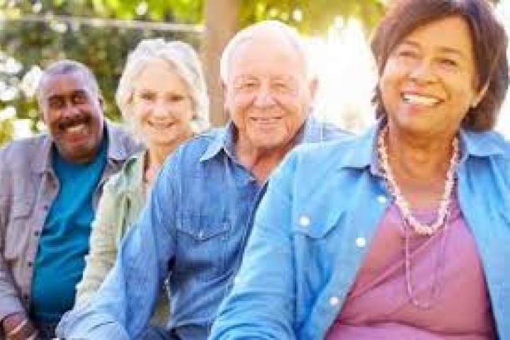 Elderly people sitting outside smiling 