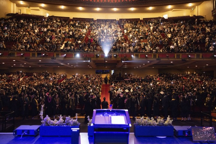 View from the stage of a Cal State LA commencement ceremony, showing a packed auditorium with graduates and guests.