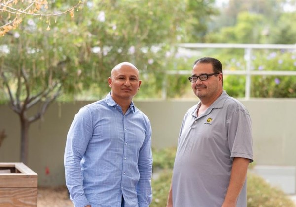 Two people pose outdoors on campus as part of the Pathways program.